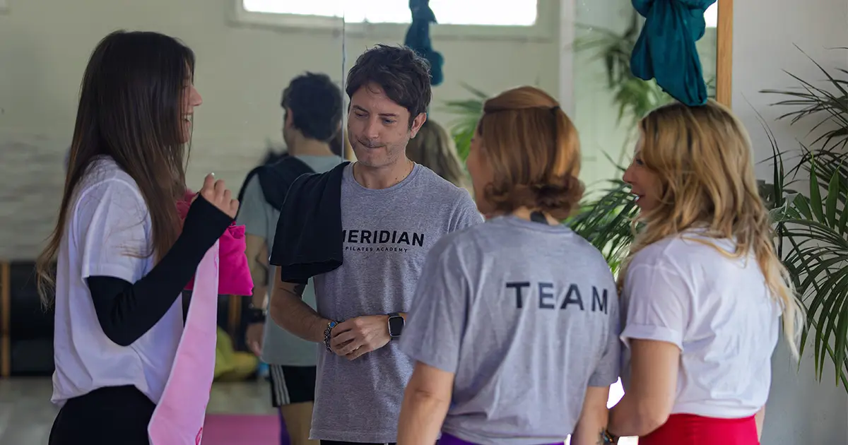 Istruttore conduce una lezione di Pilates di gruppo in palestra